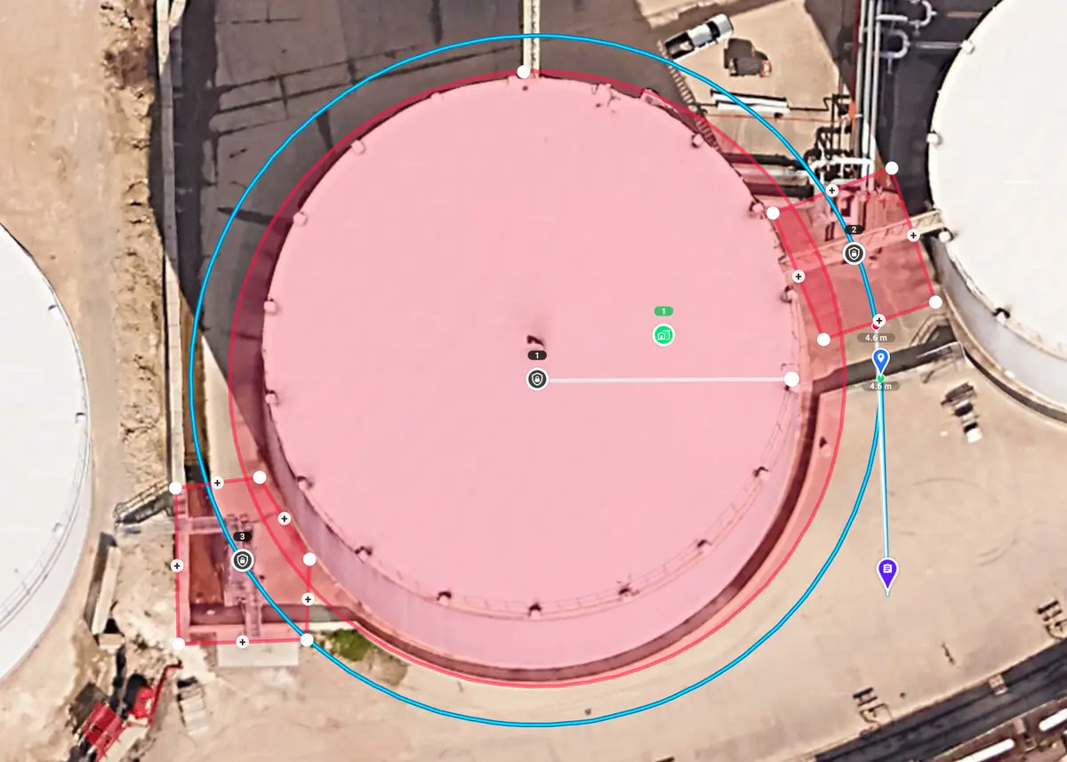 Vertical inspection mission planned around a storage tank, with red restriction zones over the tank and two platforms at its edge